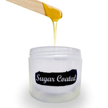 Load image into Gallery viewer, Sugar Coated jar with product dripping from wooden spatula into jar.