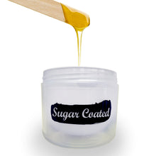 Load image into Gallery viewer, Sugar Coated jar with product dripping from wooden spatula into jar.
